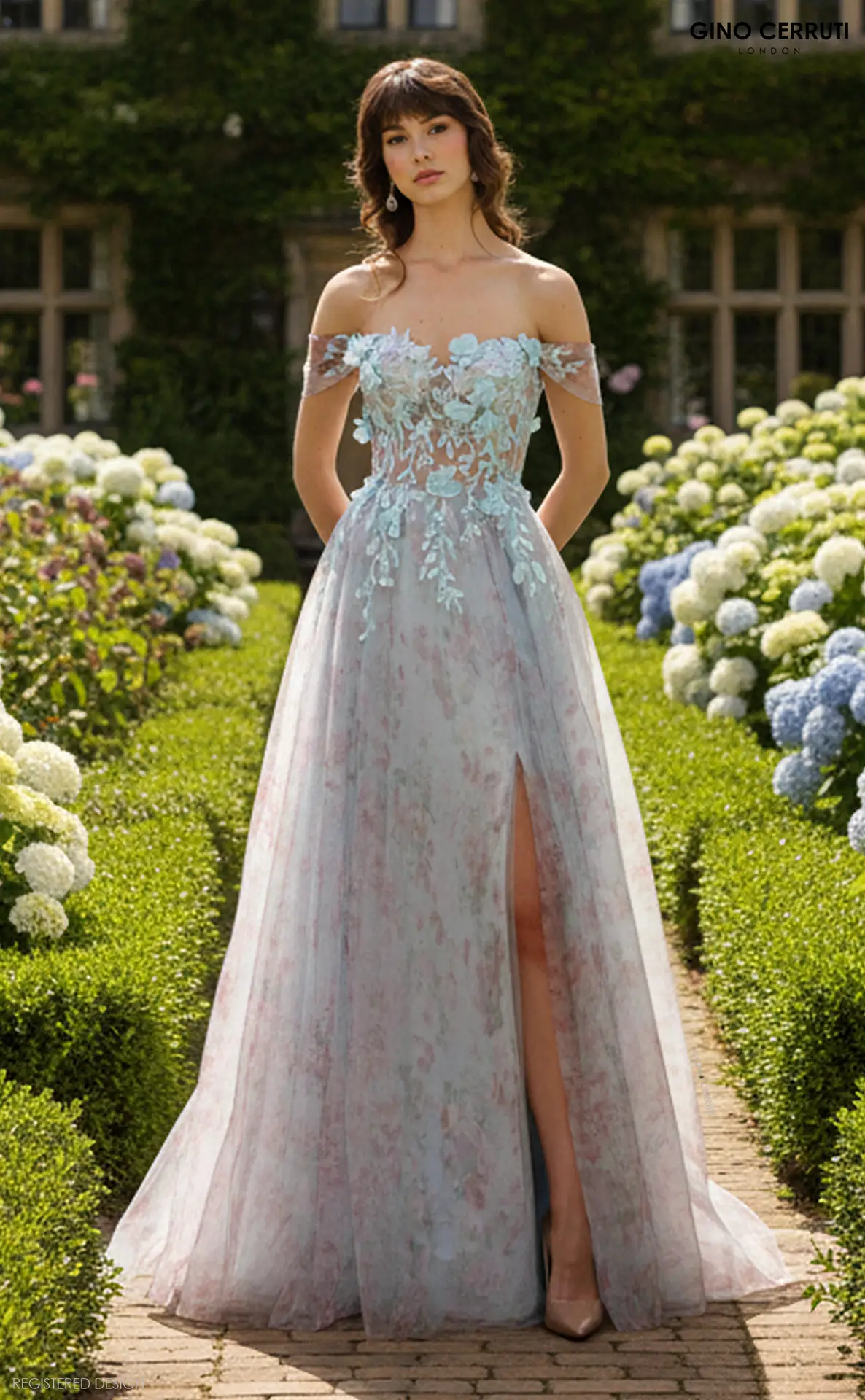 Florence by Gino Cerruti (Shimmering Sky) Soft A-line silhouette with flowing floral-printed overlay Off-the-shoulder sleeves with illusion corset bodice Baby blue 3D floral appliqué and sequin embroidery Lace-up corset back and front leg slit Exclusive to MK Prom Romantic and whimsical with a touch of modern sparkle, Florence in Shimmering Sky is made for girls who want to feel like they’ve stepped straight out of a secret garden.